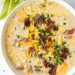 corn chowder in a bowl topped with bacon and cheddar cheese