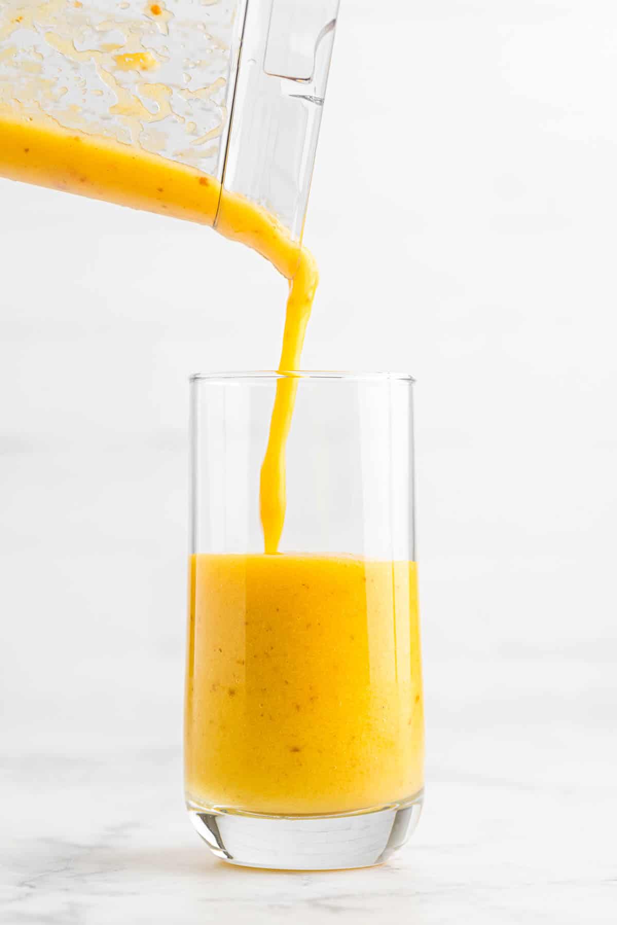 pouring smoothie into glass