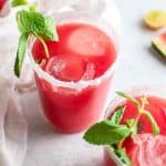 a glass of watermelon paloma with spring of fresh mint
