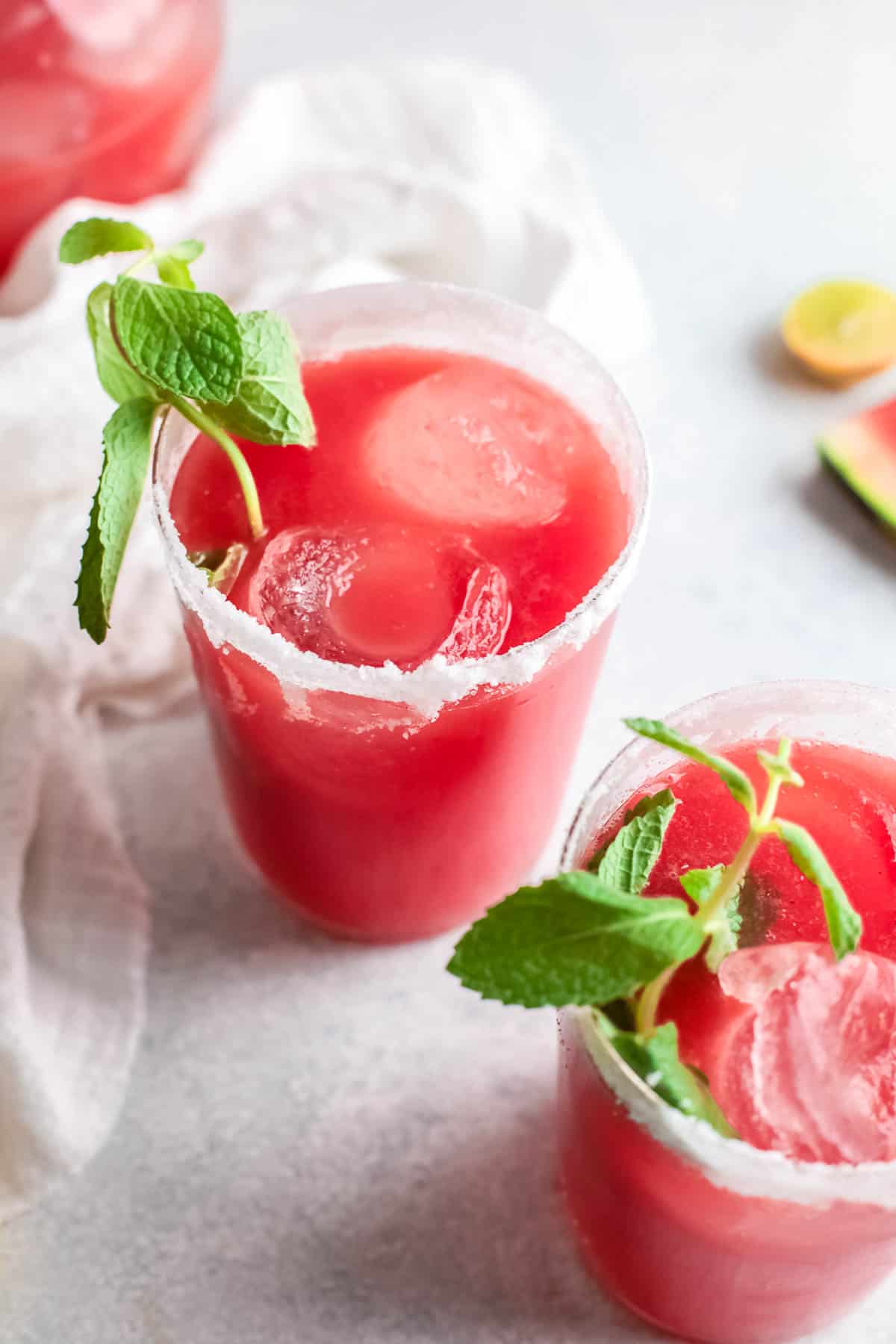 a glass of watermelon paloma with spring of fresh mint