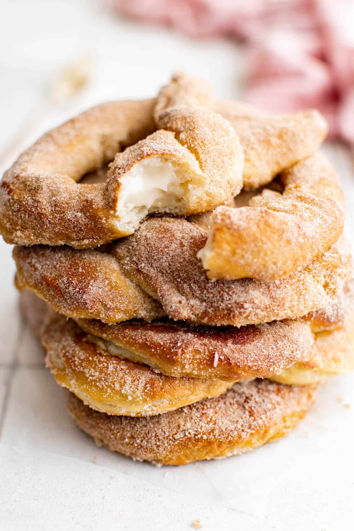 a stack of stuffed pretzels with a bit out of one pretzel to show the cream cheese filling