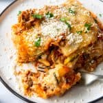 a slice of zucchini lasagna on a plate with a bite taken out with a fork