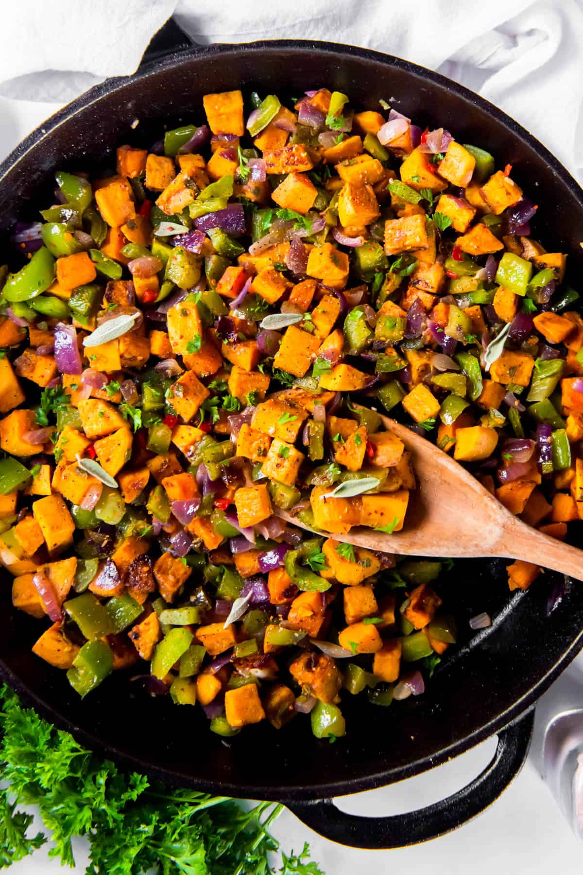 cooked sweet potato hash in a black skillet on a white countertop