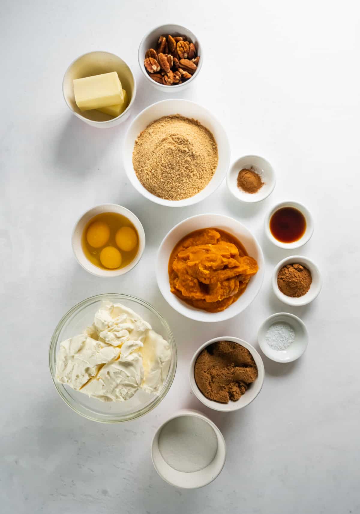 all of the ingredients for pumpkin cheesecake bars on a white countertop