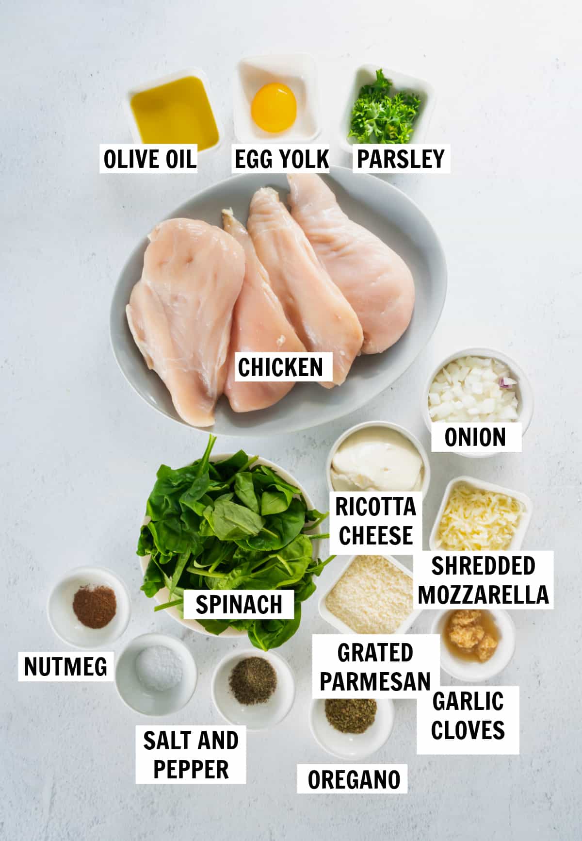 all of the ingredients needed for spinach ricotta chicken on a white tabletop