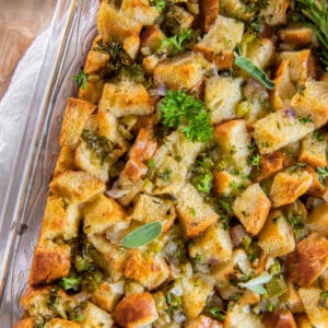 thanksgiving stuffing in a casserole dish with fresh herbs on top