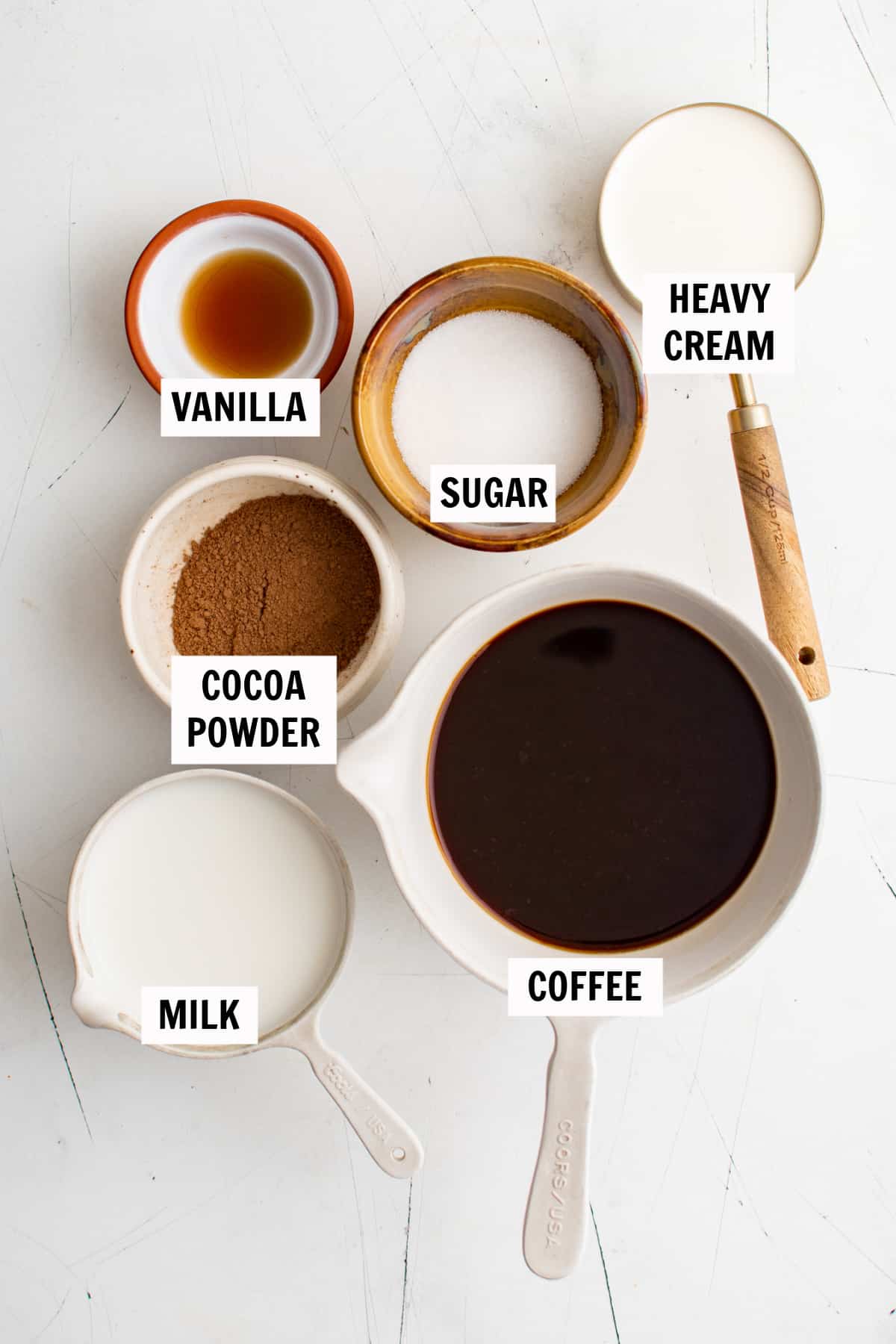 all of the ingredients for a mocha latte on a white countertop