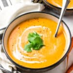 a bowl of carrot soup with a spoon in it