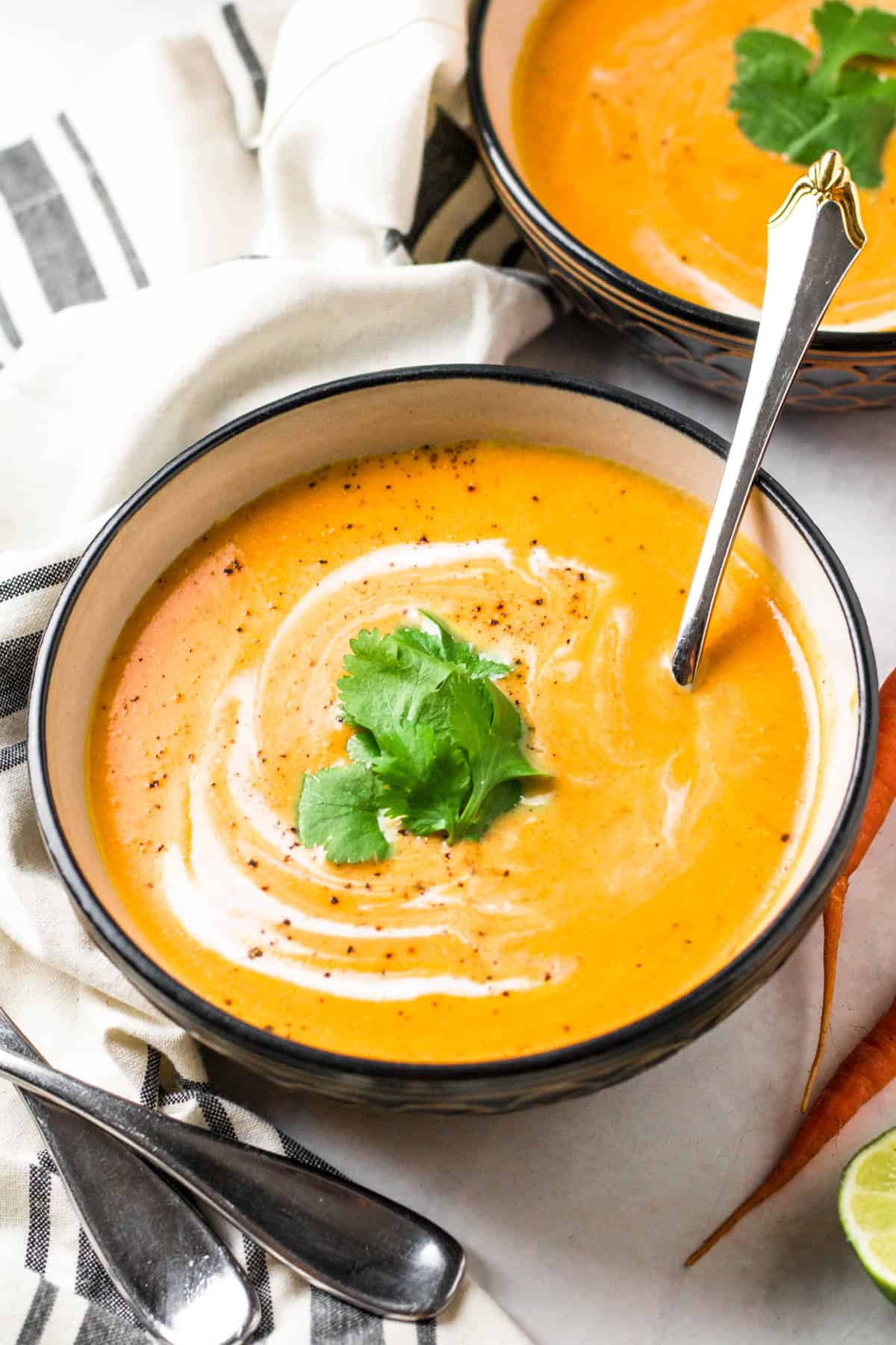 a bowl of carrot soup with a spoon in it