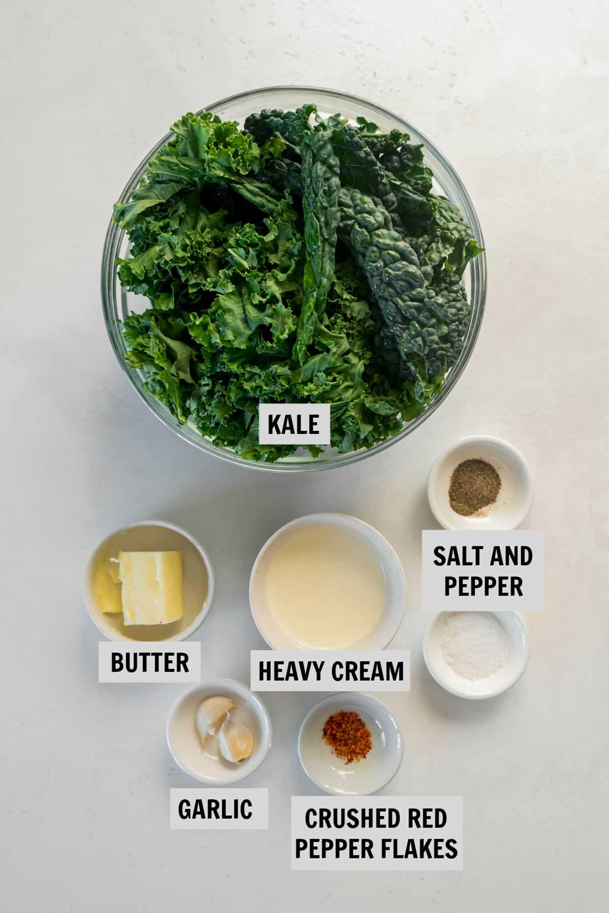 all of the ingredients for creamed kale on a white countertop
