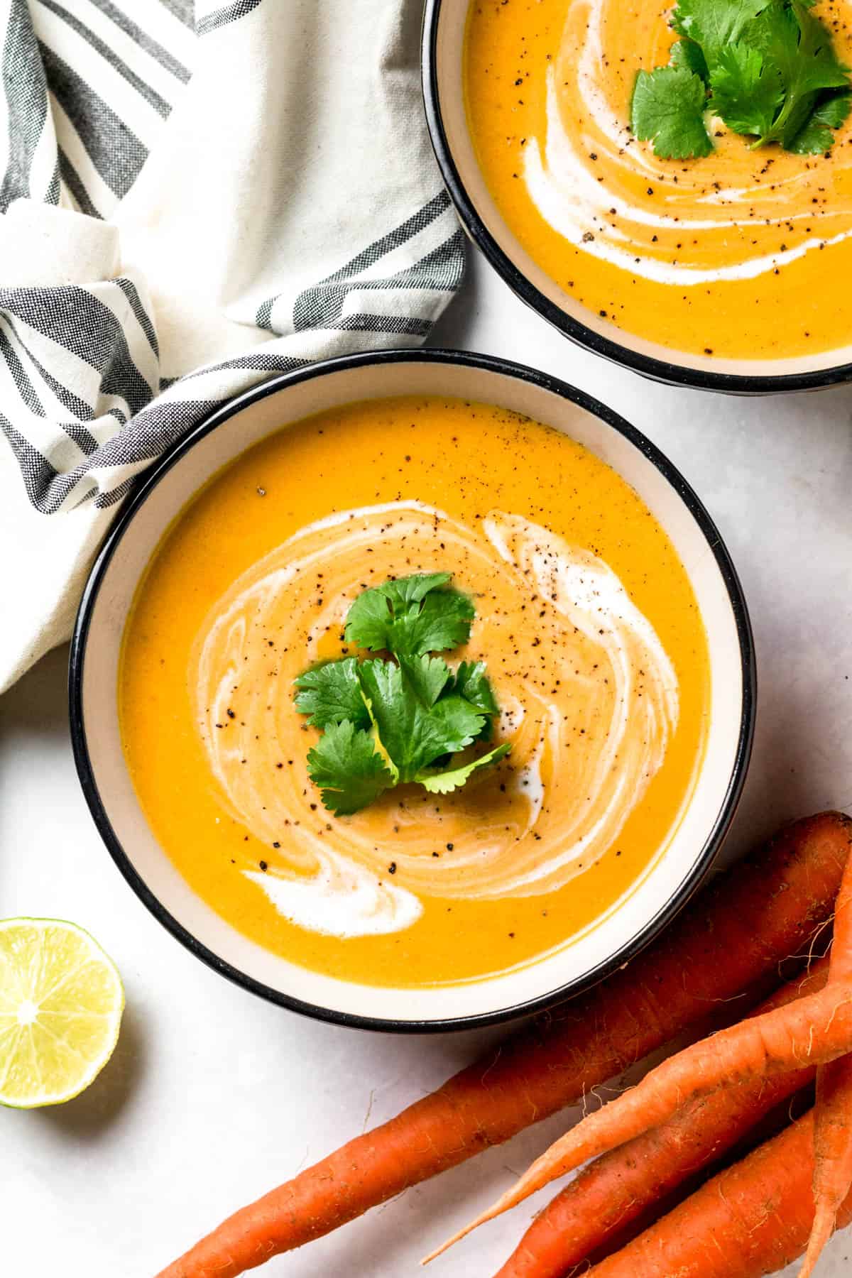 a bowl filled with carrot soup and garnished with cilantro