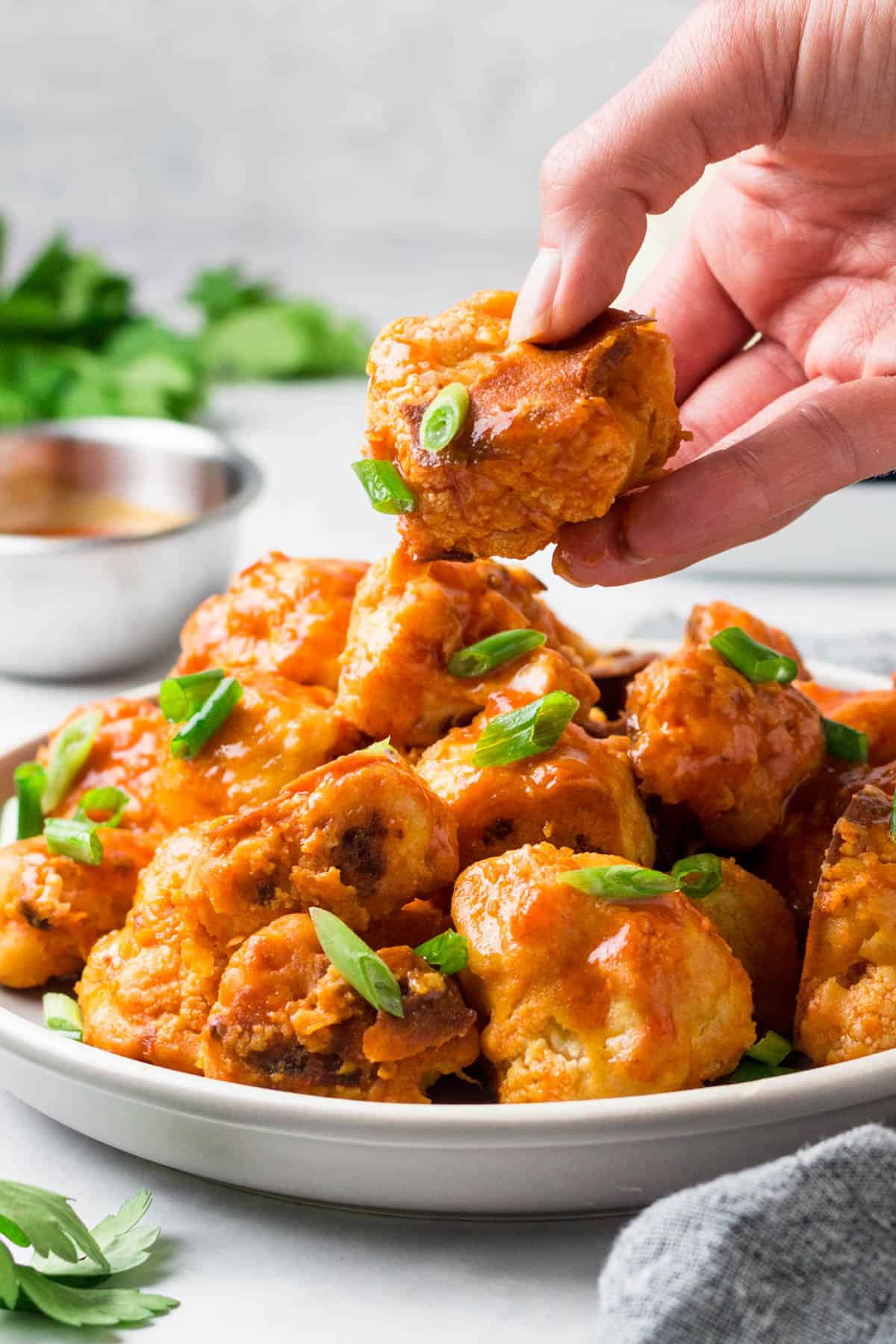 a hand picking up one buffalo cauliflower bite