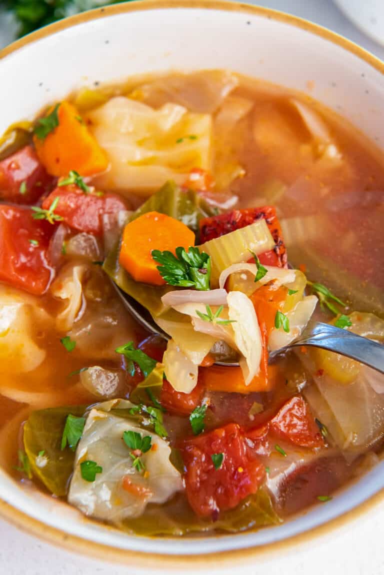 cabbage soup in a bowl with parsley garnish on top