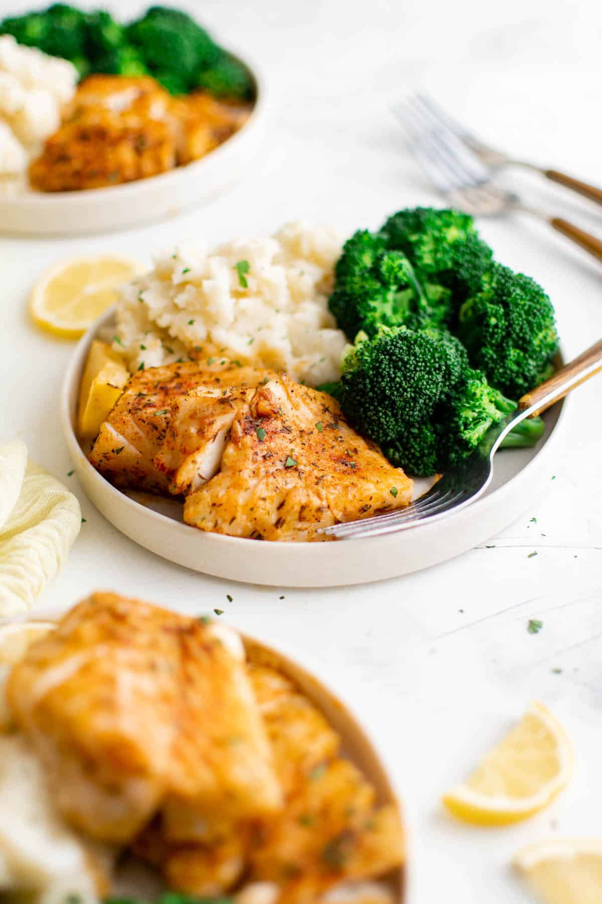 pan fried cod on a plate with mashed potatoes and broccoli