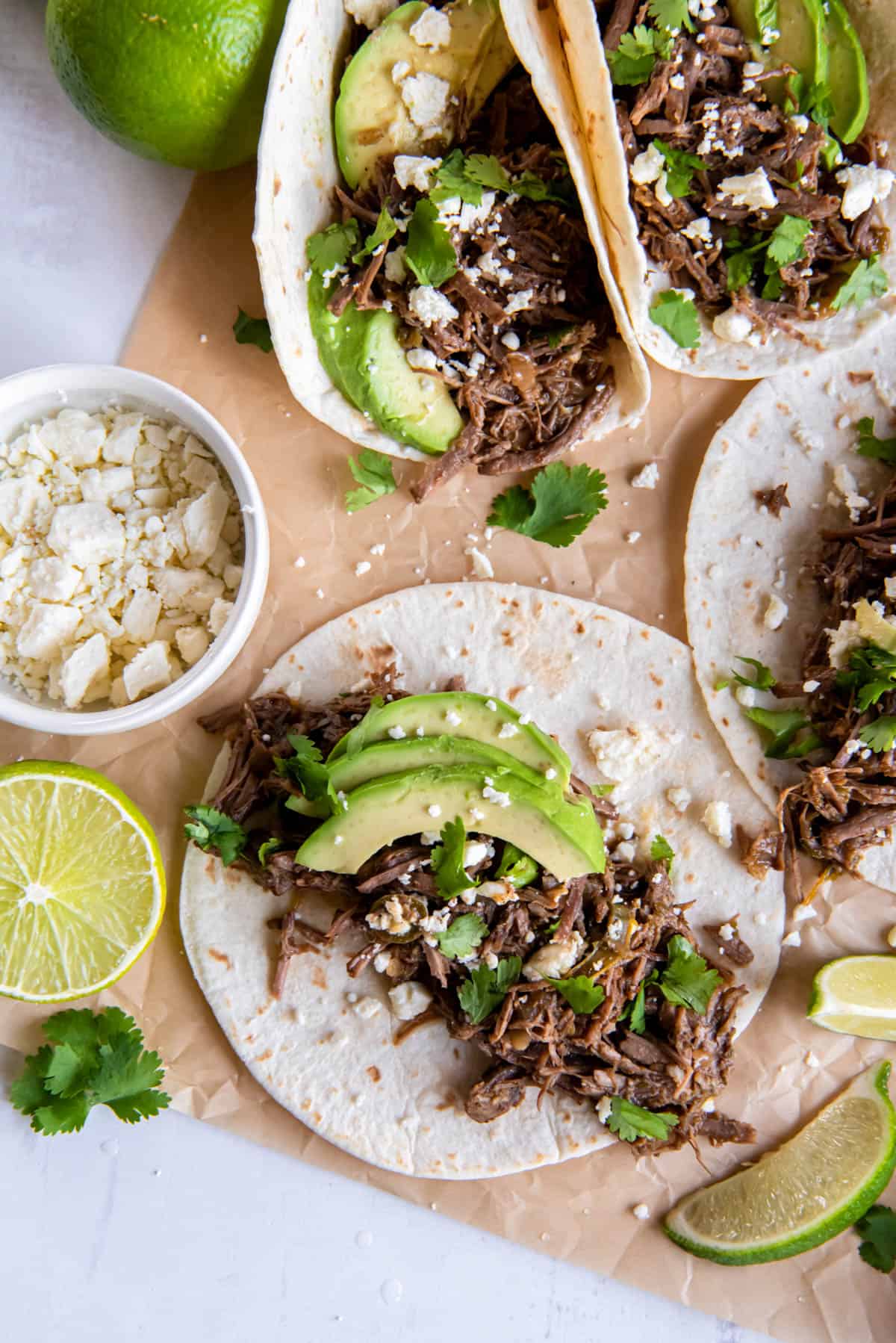 shredded beef served on tortillas and topped with avocados and cheese