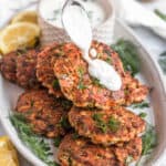 baked salmon patties on a plate topped with tartar sauce