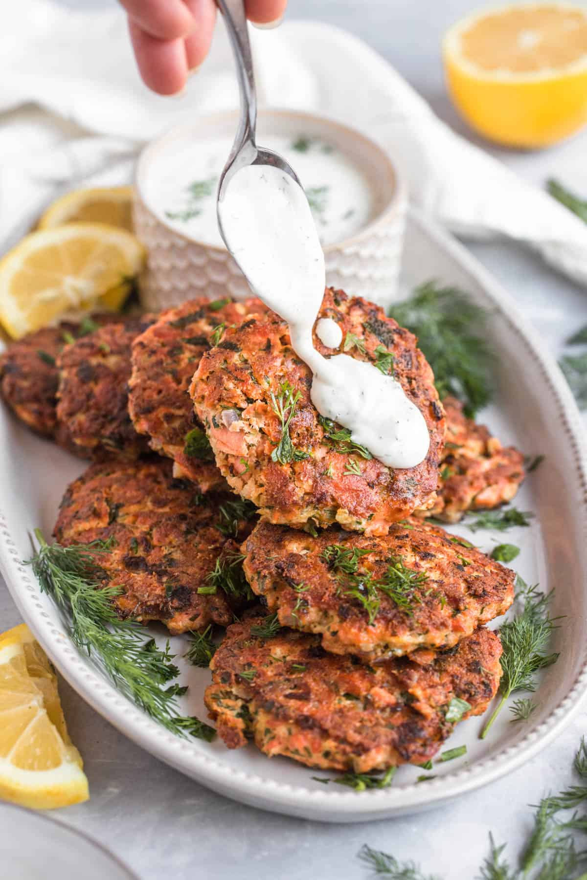 baked salmon patties on a plate topped with tartar sauce