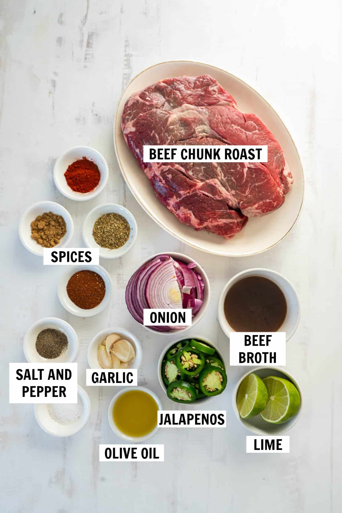 all of the ingredients for shredded beef on a white countertop