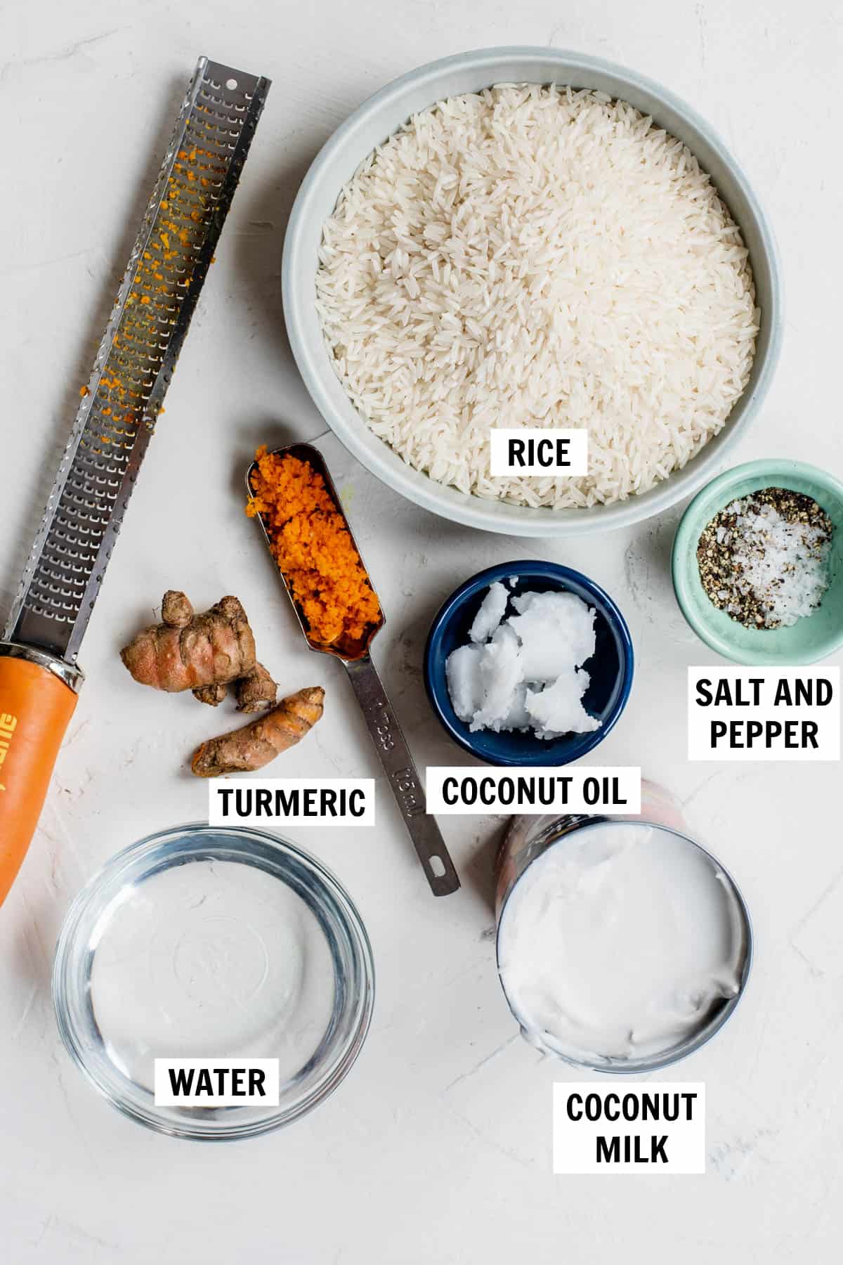 all of the ingredients for turmeric coconut rice on a white countertop