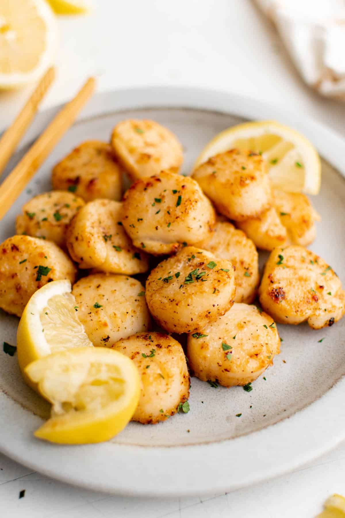Broiled sea scallops on a plate for serving.