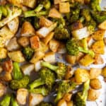 Oven roasted potatoes and broccoli on a sheet pan after baking.