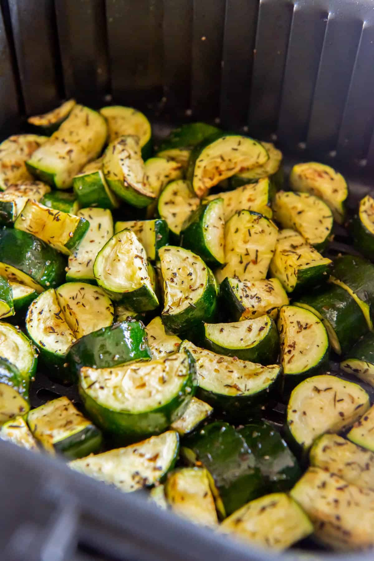 Zucchini in the air fryer basket after cooking.