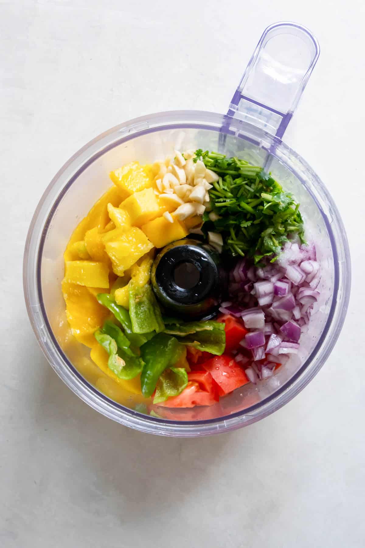 All of the ingredients for mango hanabero salsa in a food processor before blending.