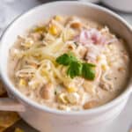 Crockpot Cream Cheese Chicken Chili in a bowl with cheese on top and chopped cilantro.
