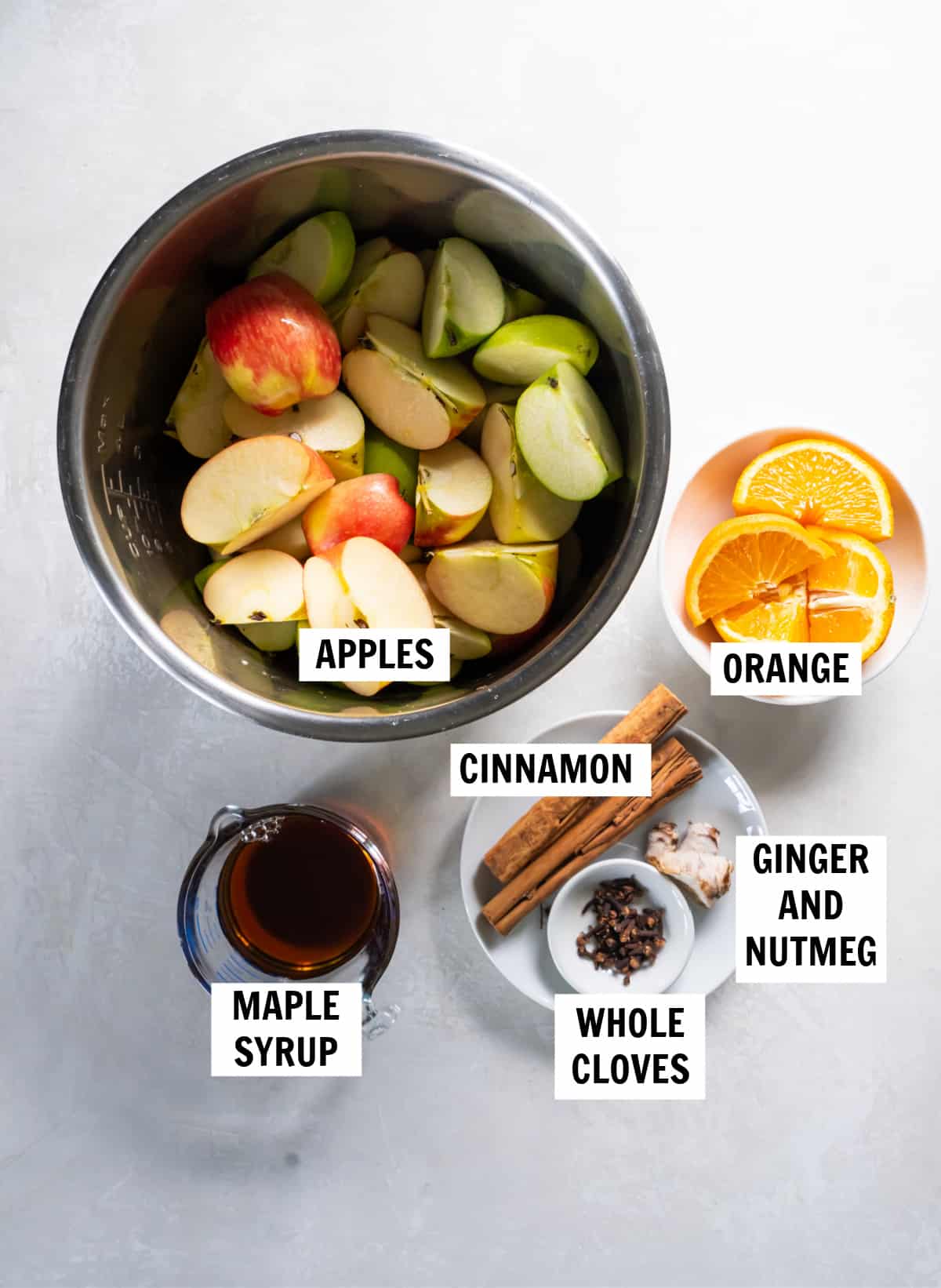 All of the ingredients for the instant pot apple cider on a white countertop.