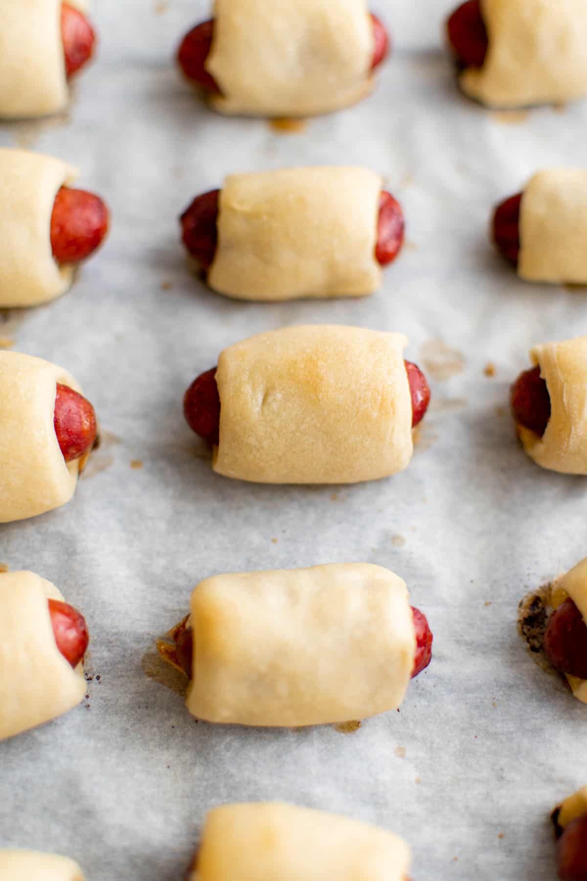 Pigs in a blanket on a sheet pan after cooking in the oven.