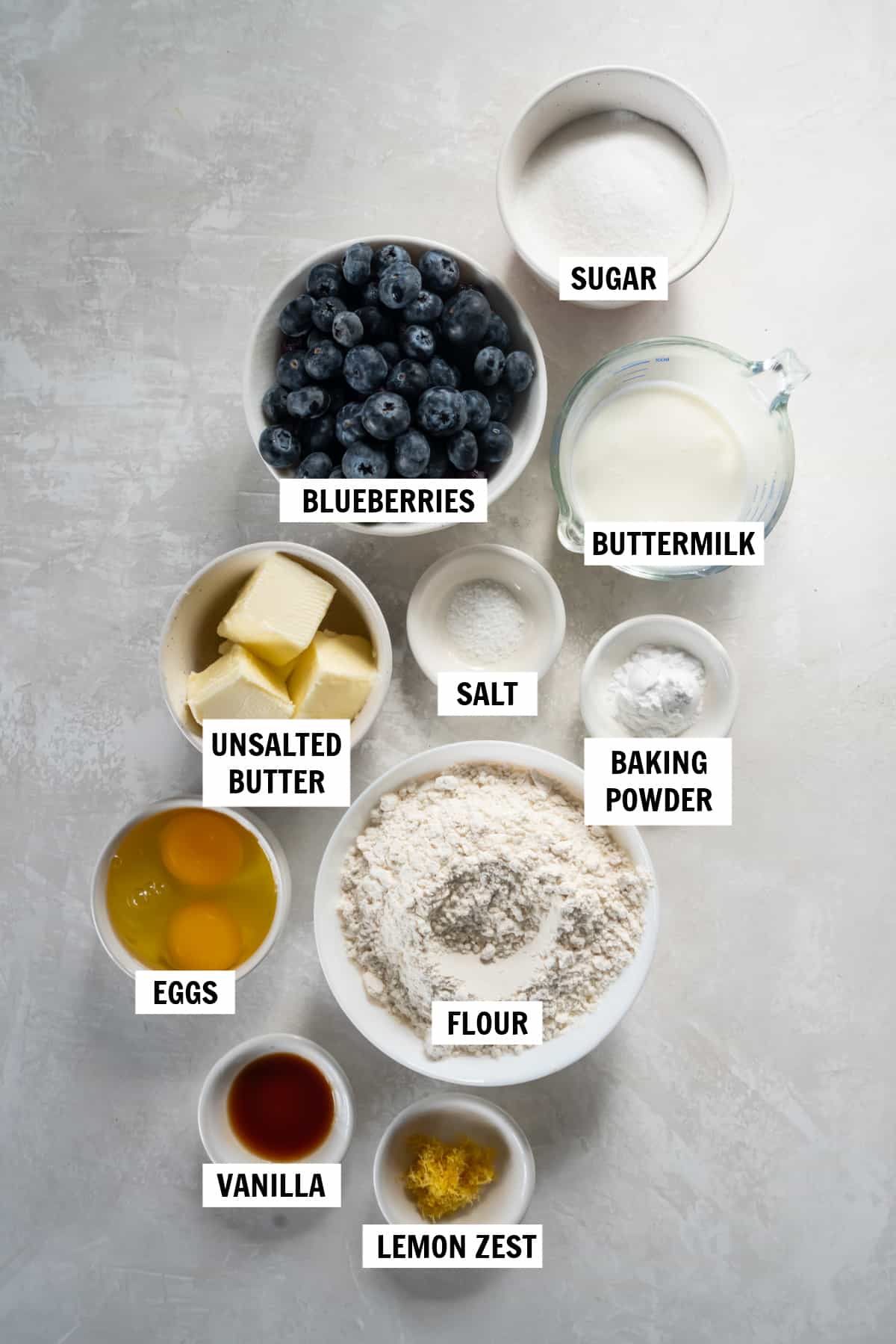 All of the ingredients for mini blueberry muffins on a white countertop.