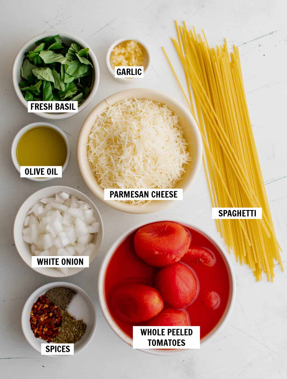 All of the ingredients for spaghetti arrabbiatta on a white countertop.