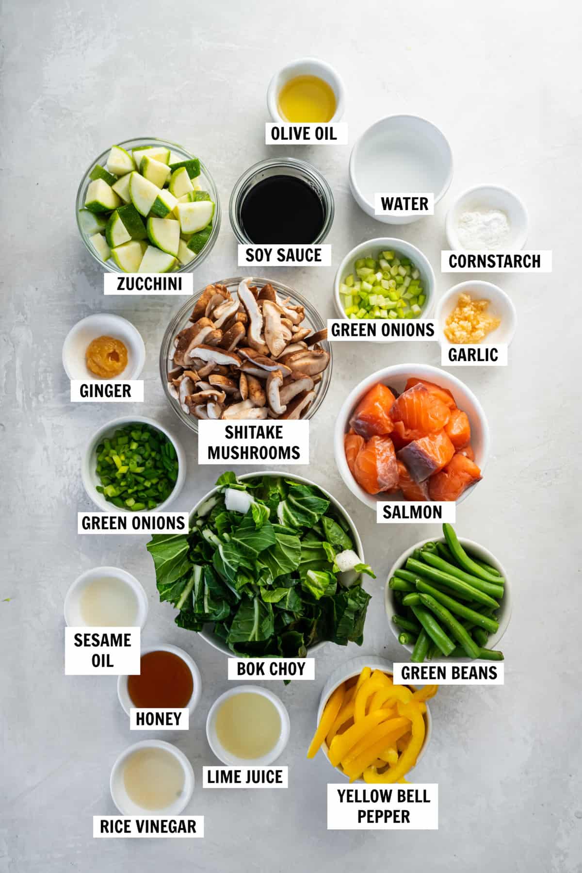 All of the ingredients for the salmon stir fry and teriyaki sauce are on a white countertop.