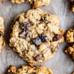 A closeup photo of gluten free oatmeal raisin cookies on a cookie sheet after baking.