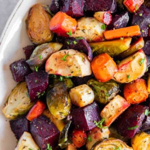 Honey roasted vegetables in a white serving dish ready to be served.