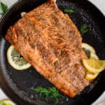 A cooked salmon filet in a cast iron ready for serving.