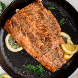 A cooked salmon filet in a cast iron ready for serving.