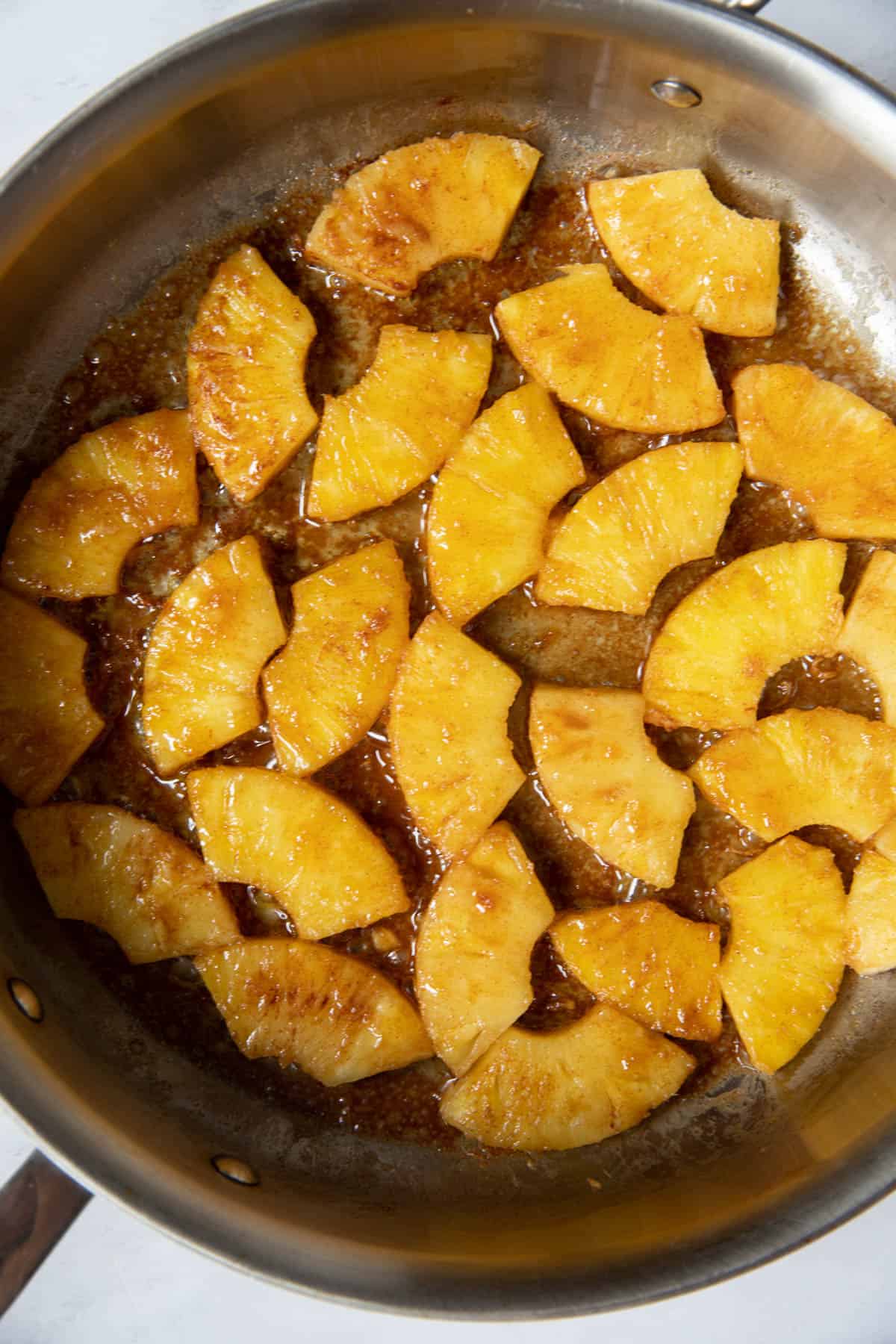 The prepare pineapple in a skillet for cooking in the butter.