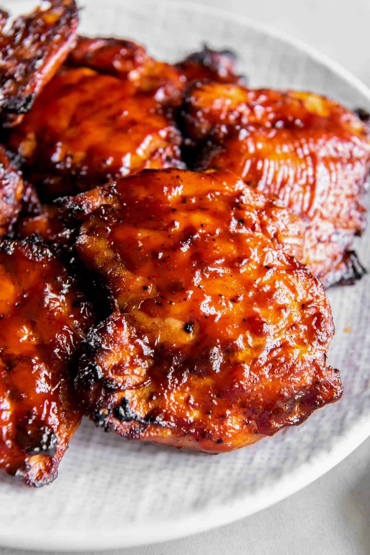 BBQ boneless skinless chicken thighs on a plate for serving.