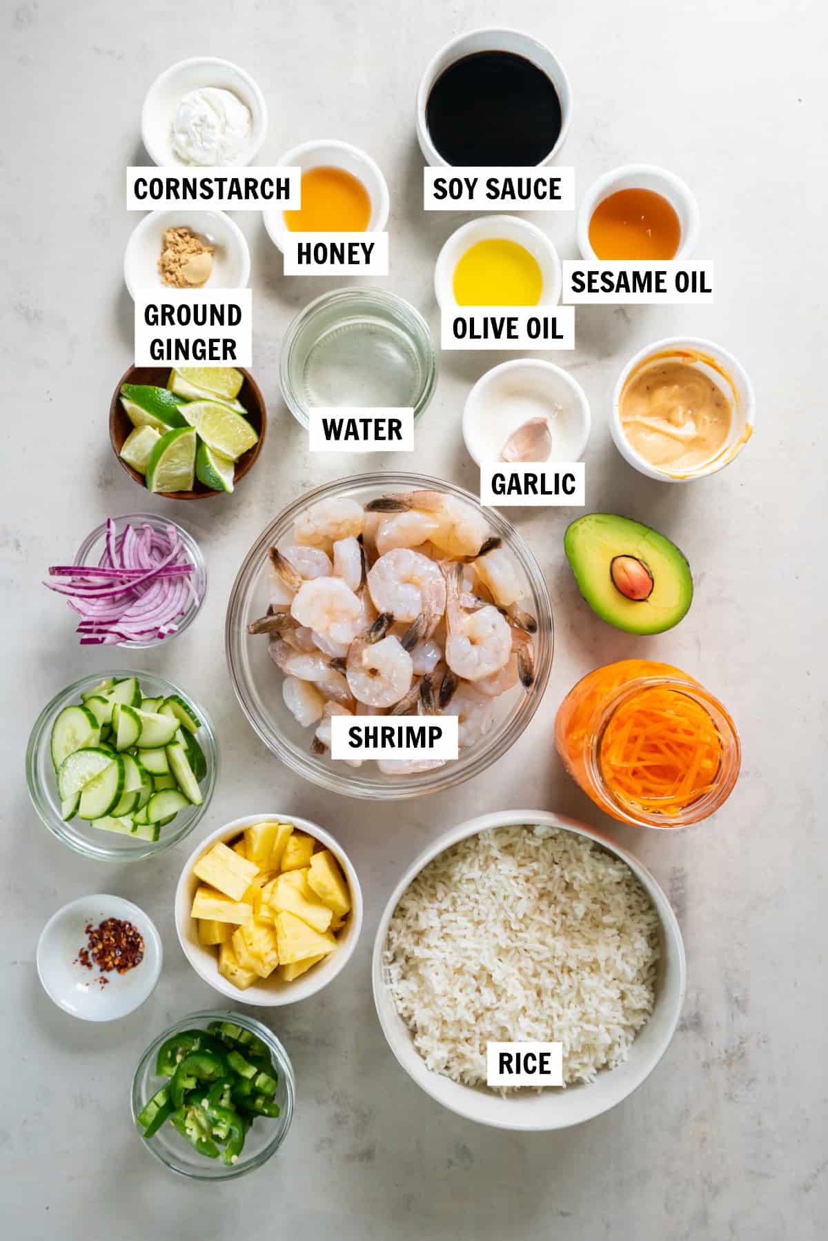 All of the ingredients for shrimp and rice bowl on a white countertop including rice, shrimp, soy sauce, honey, ground ginger, olive oil, cornstarch and water.