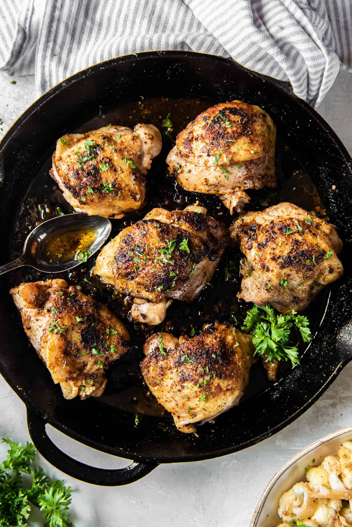 Cast Iron Chicken thighs in a black cast iron pan ready to be served.
