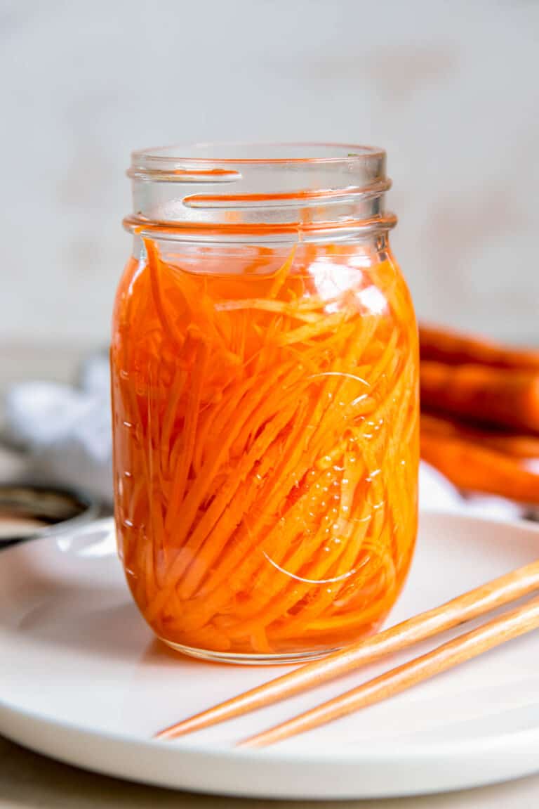 lose-up of shredded carrots in brine, quick pickled carrot recipe with rice vinegar, perfect fridge pickles in 15 minutes.