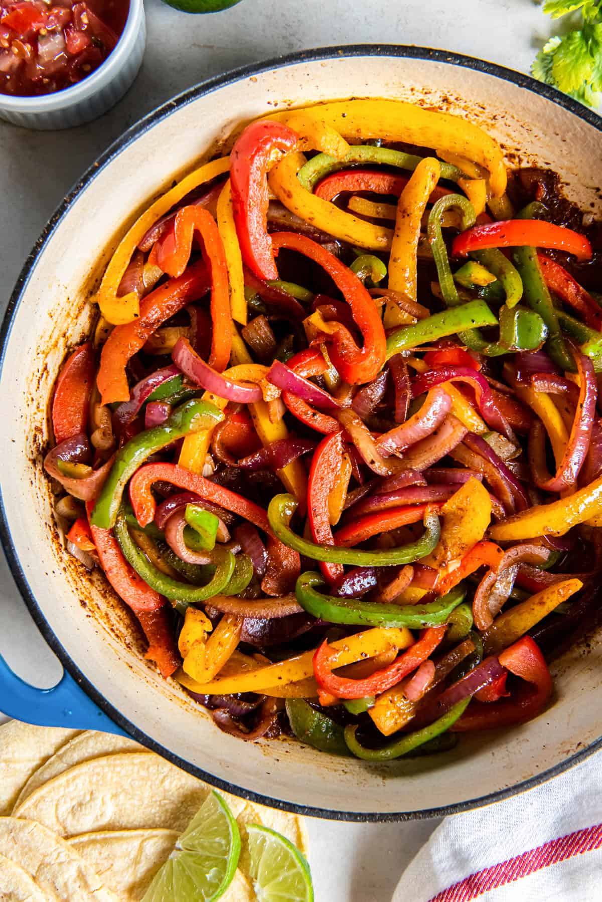 A skillet filled with fajita veggies that is ready for serving. 