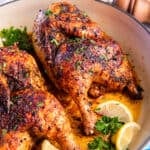 Roasted half chicken in a baking dish ready to be served.
