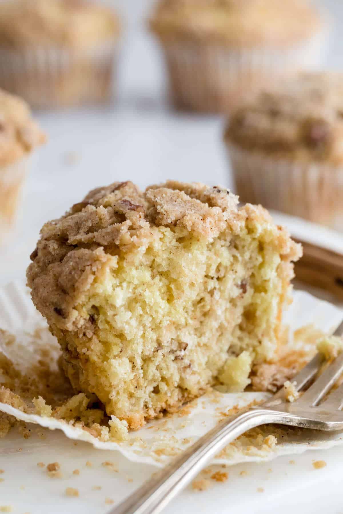Sliced coffee cake muffin showing a moist, tender crumb with cinnamon streusel topping.