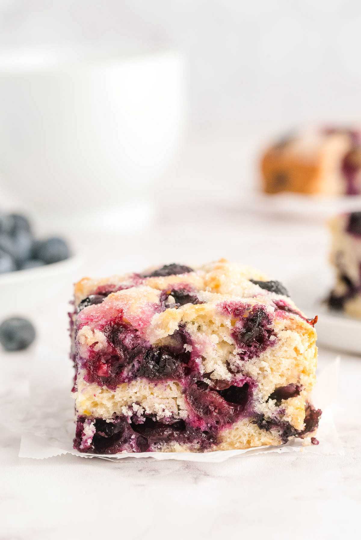 Close-up of blueberry breakfast cake with a golden sugar top and baked fresh blueberries.