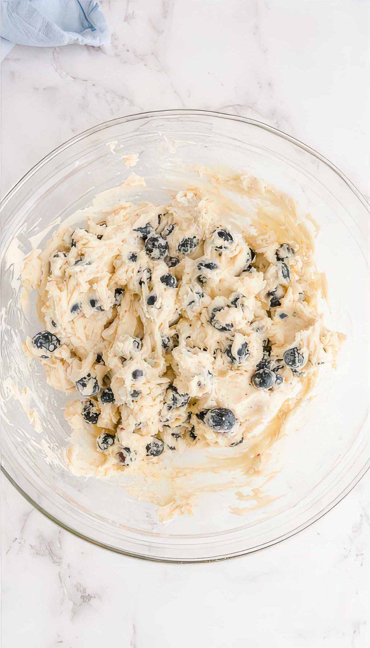 Thick blueberry breakfast cake batter with fresh blueberries folded into the mixture.