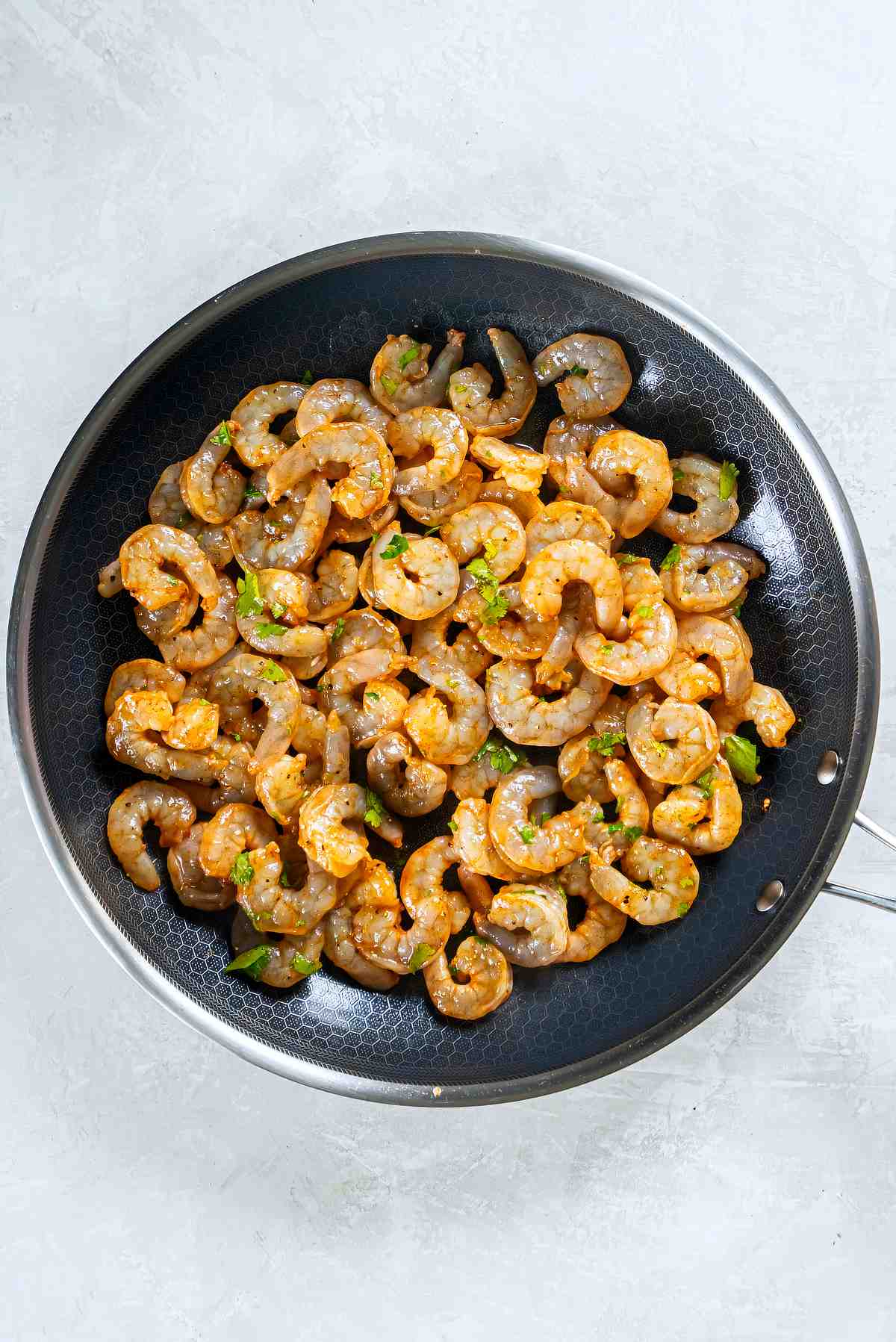 Shrimp cooking in a skillet until pink and opaque for cilantro lime shrimp tacos
