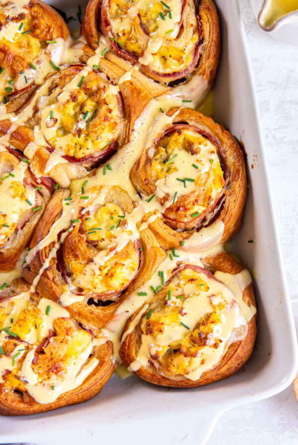 Close-up of flaky Eggs Benedict Breakfast Roll drizzled with hollandaise sauce.