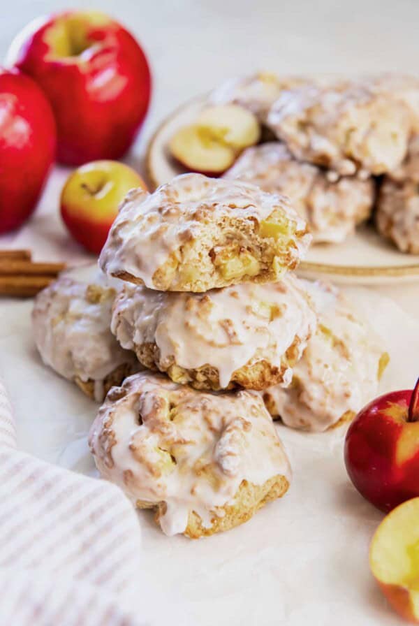 Glazed air fryer applesauce fritters stacked on a plate, showing the soft apple pieces inside and the golden brown edges.